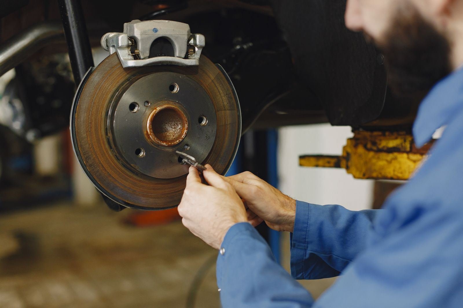 Photo – mechanic working on a car brake disc