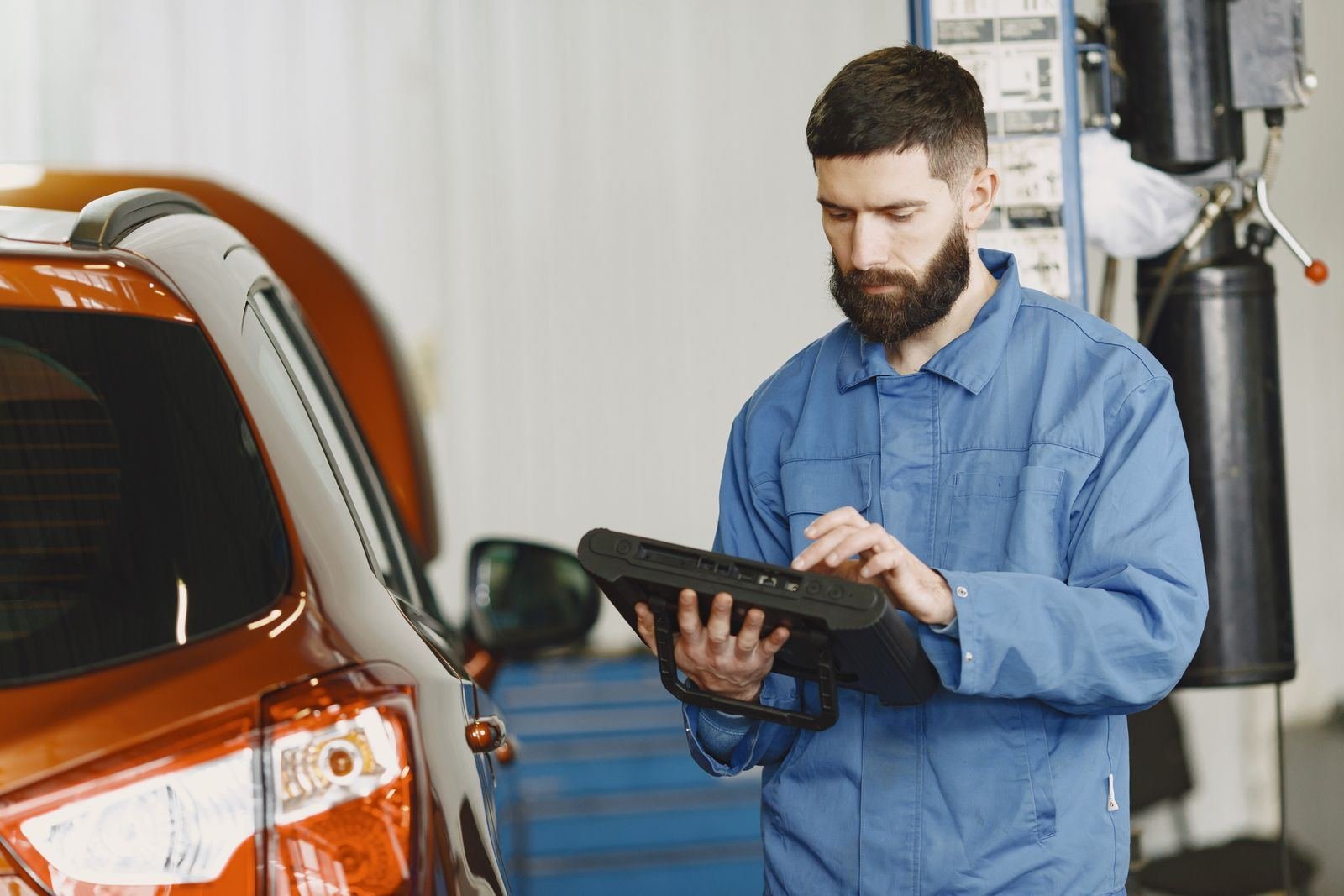 Photo – mechanic scanning a car with a diagnostic tablet